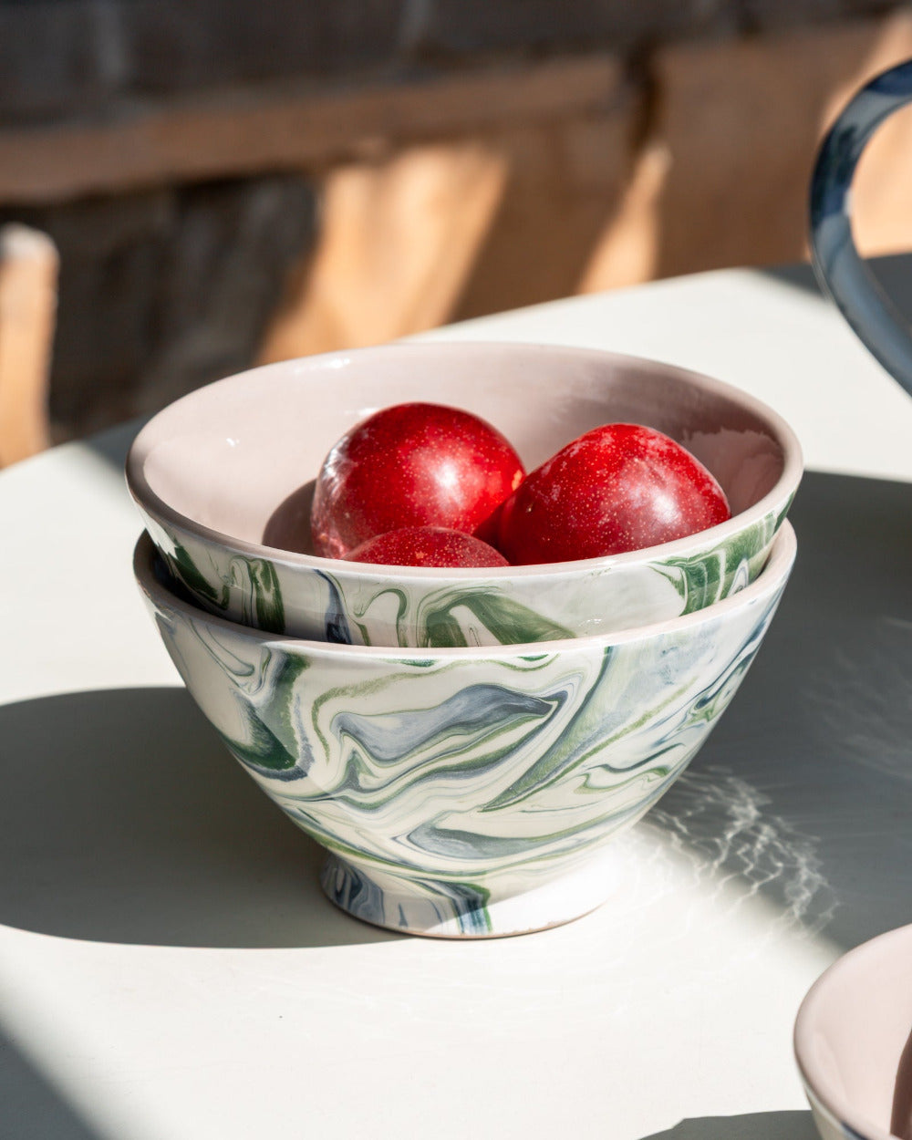 Marbled patterned bowl with red fruits on a white surface
