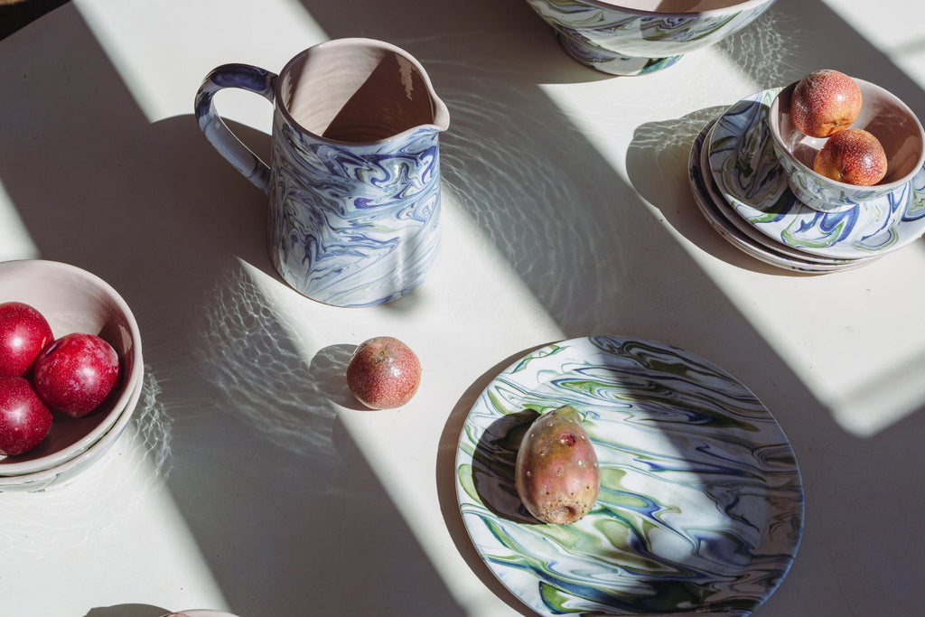 Ceramic tableware with marbled patterns on a white surface.