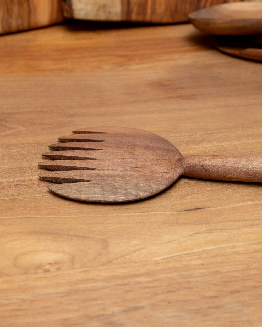 Wooden salad server on a wooden surface