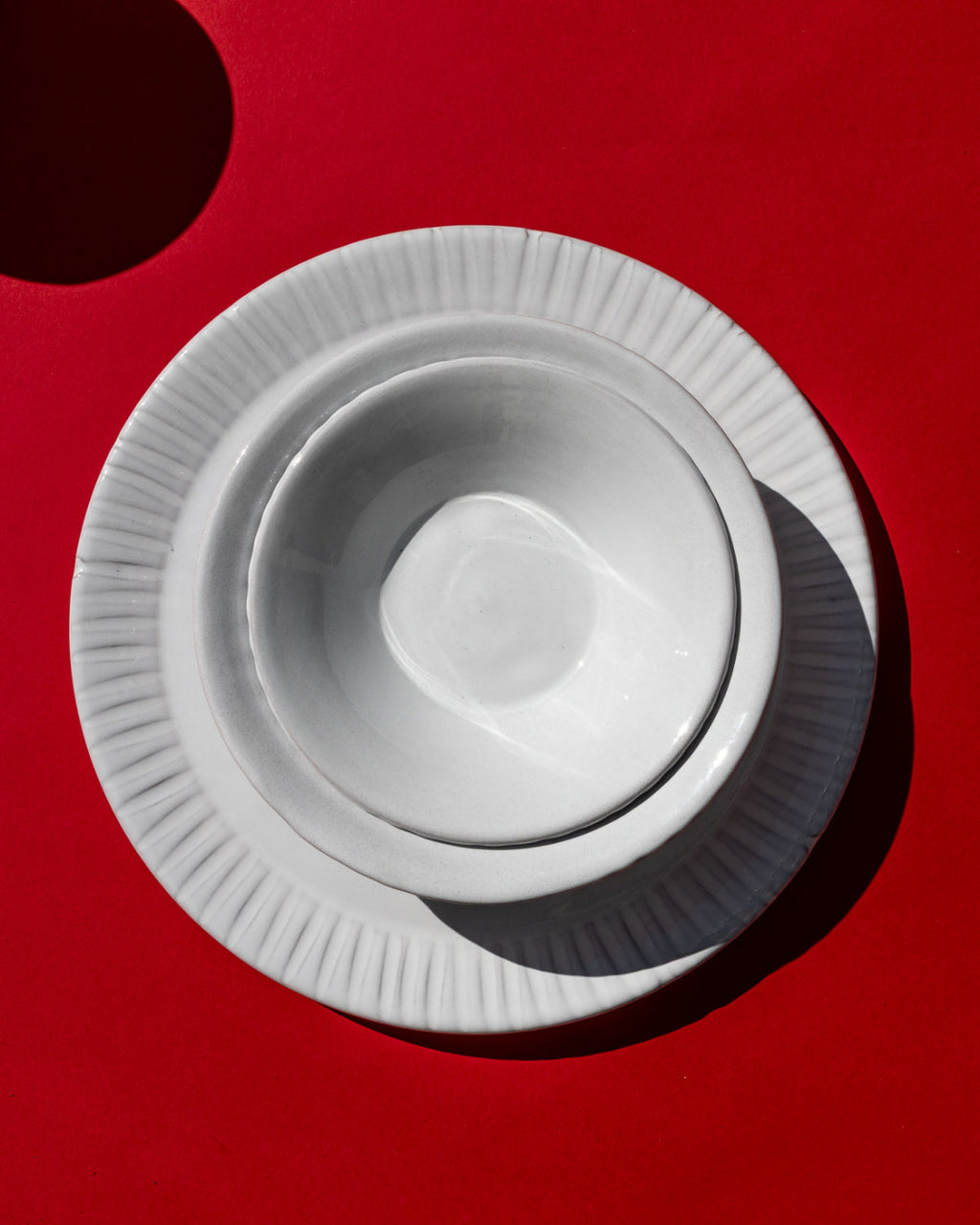 Milk White Lines ceramic plates and bowl on a red background