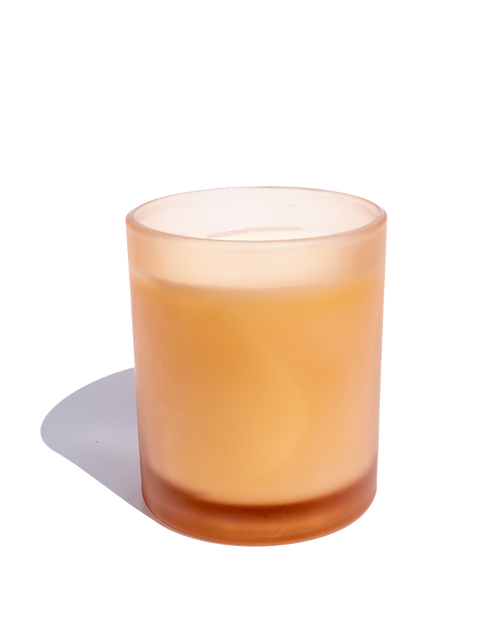 Pale orange frosted glass candle on a white background