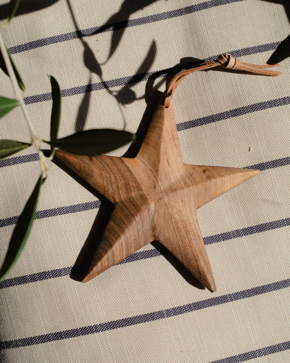 Wooden star ornament on a striped fabric background
