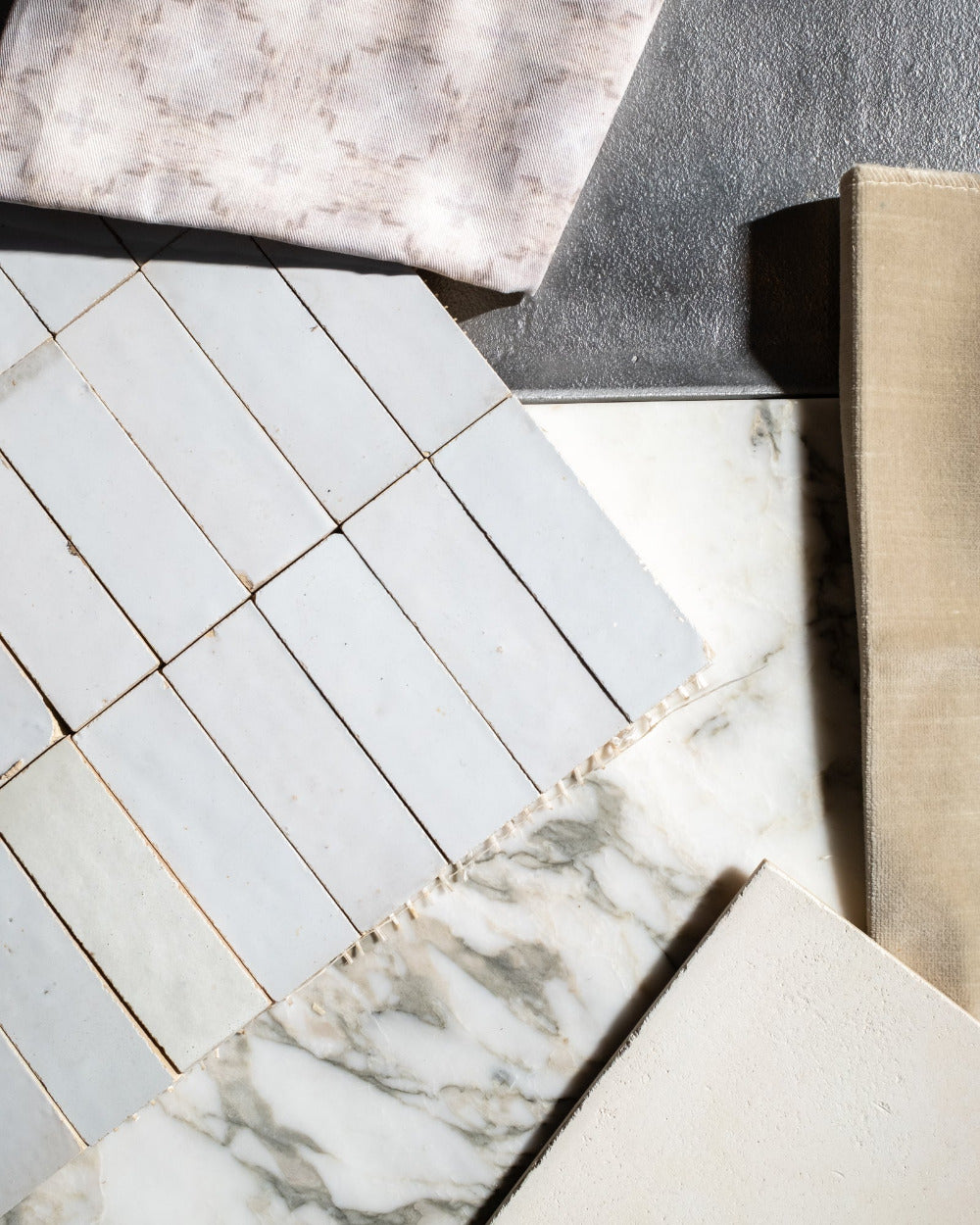 Close-up of white zelige tiles with a marble  and fabric samples