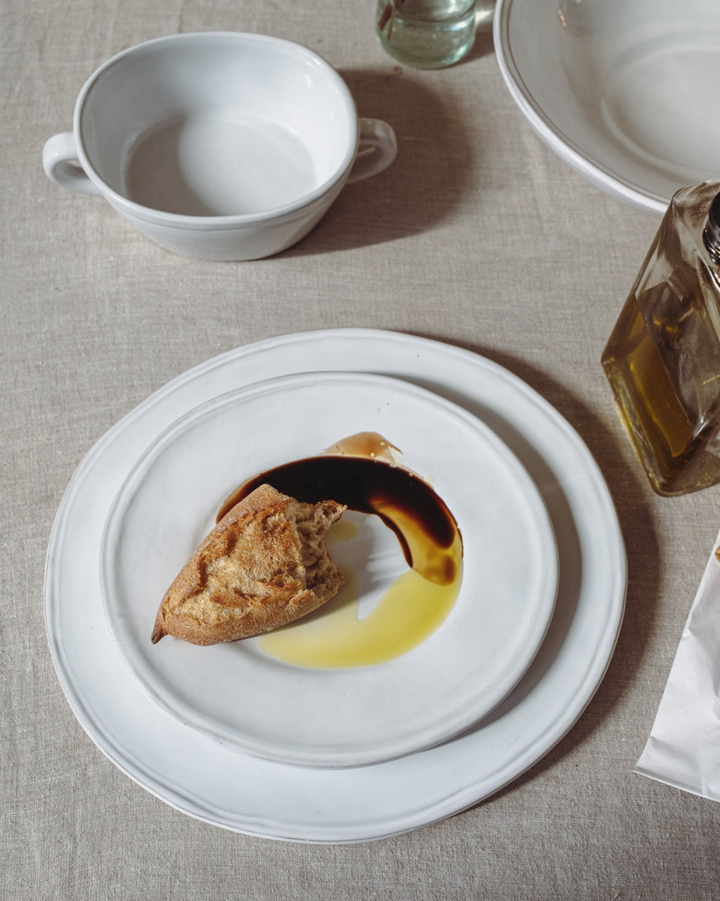 Dessert plate with a pastry and sauce on a light gray tablecloth.