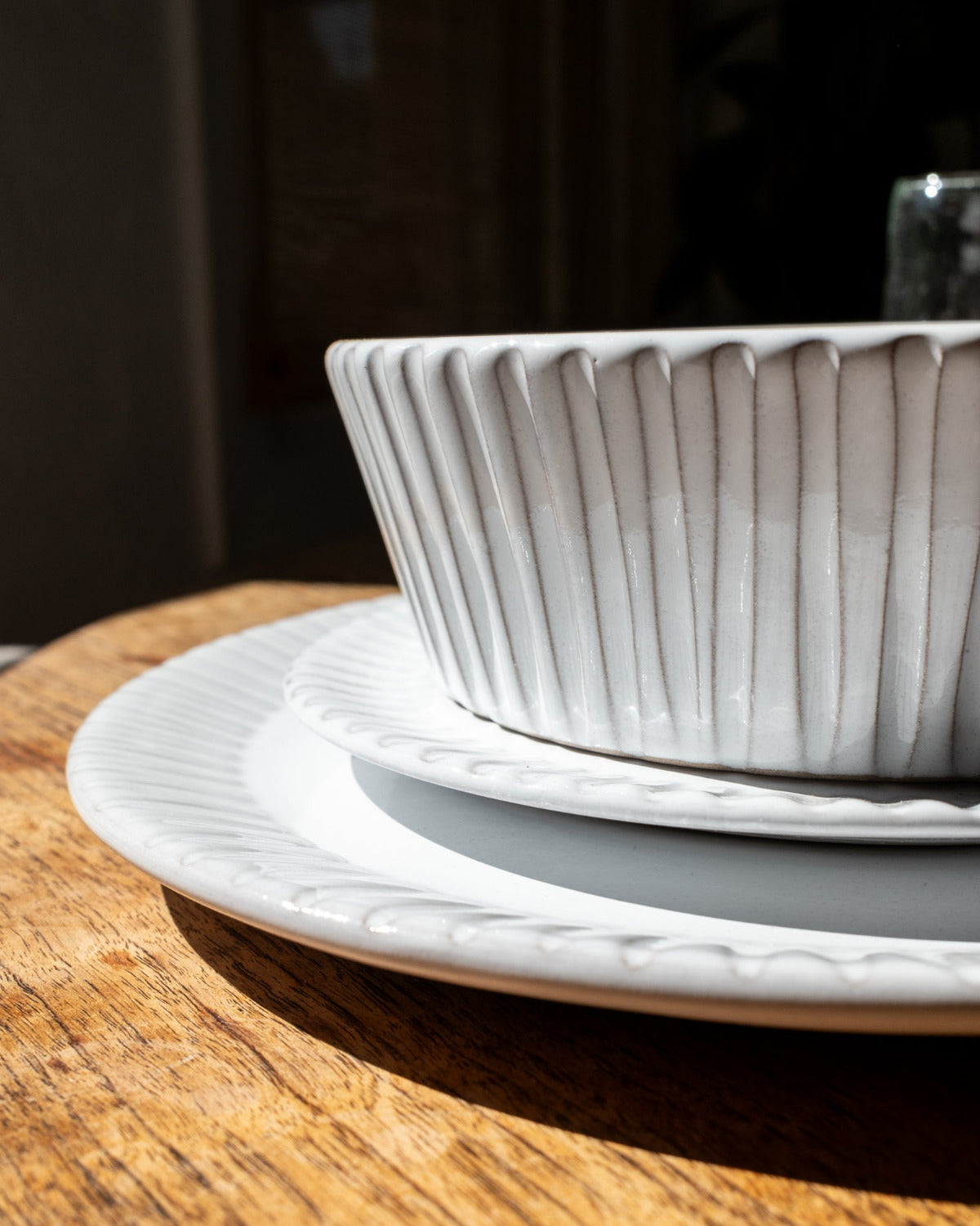 White ceramic dish with ribbed texture on a wooden surface