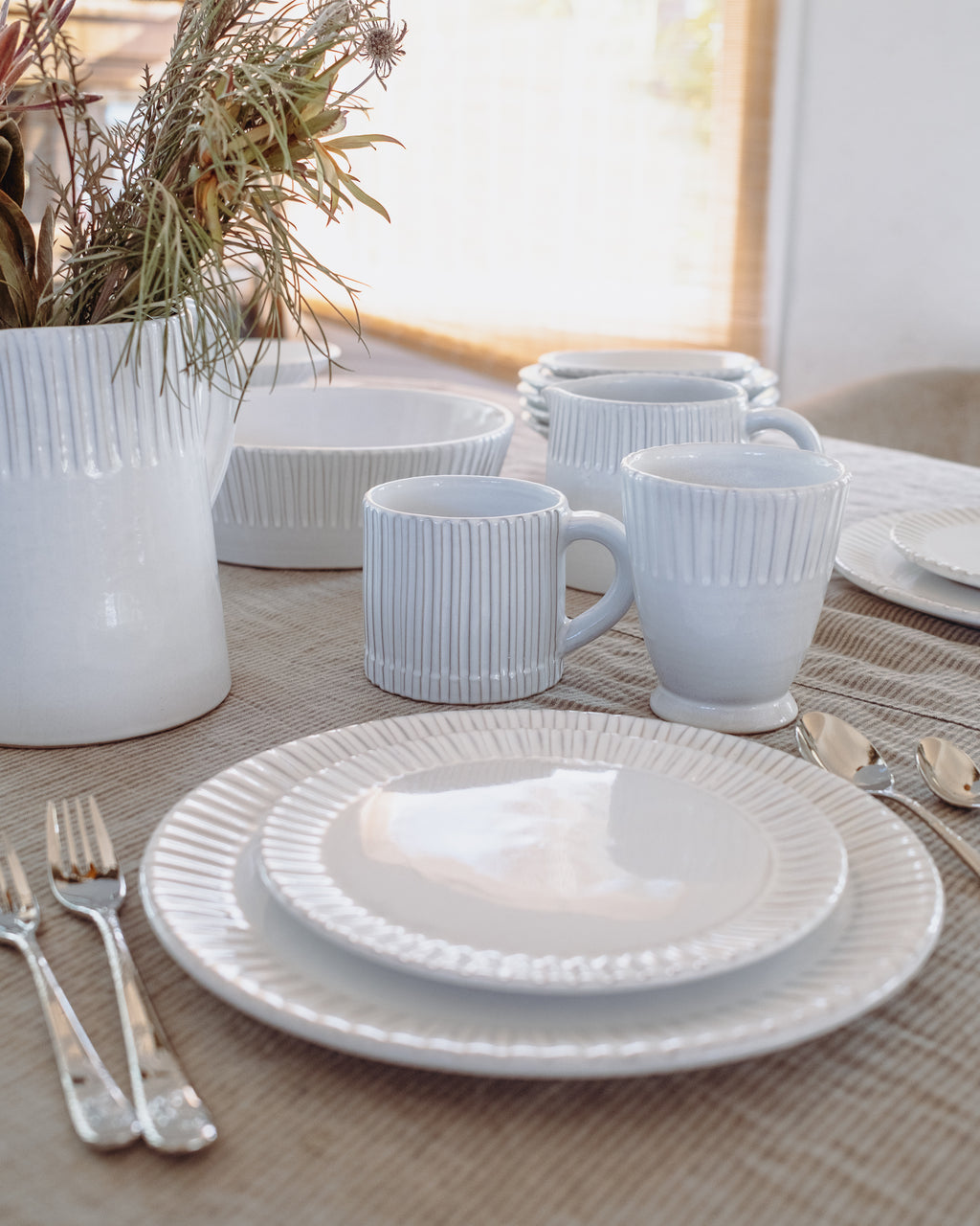 White ceramic tableware set on a table with a neutral background