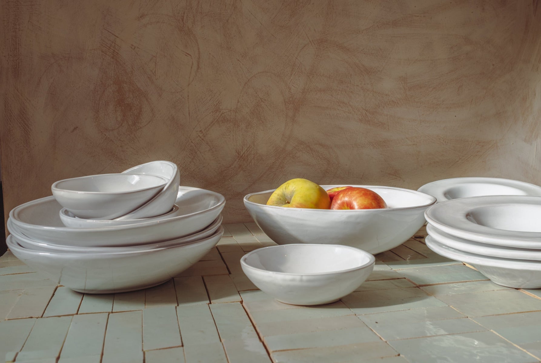 White ceramic oval bowls on a tiled tabletop with a neutral background
