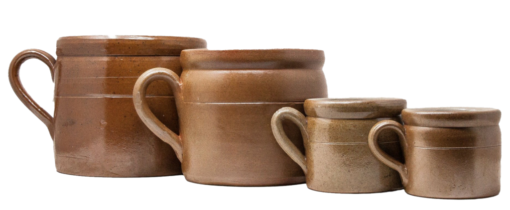 Large and small brown ceramic crocks with handles of different sizes on a white background